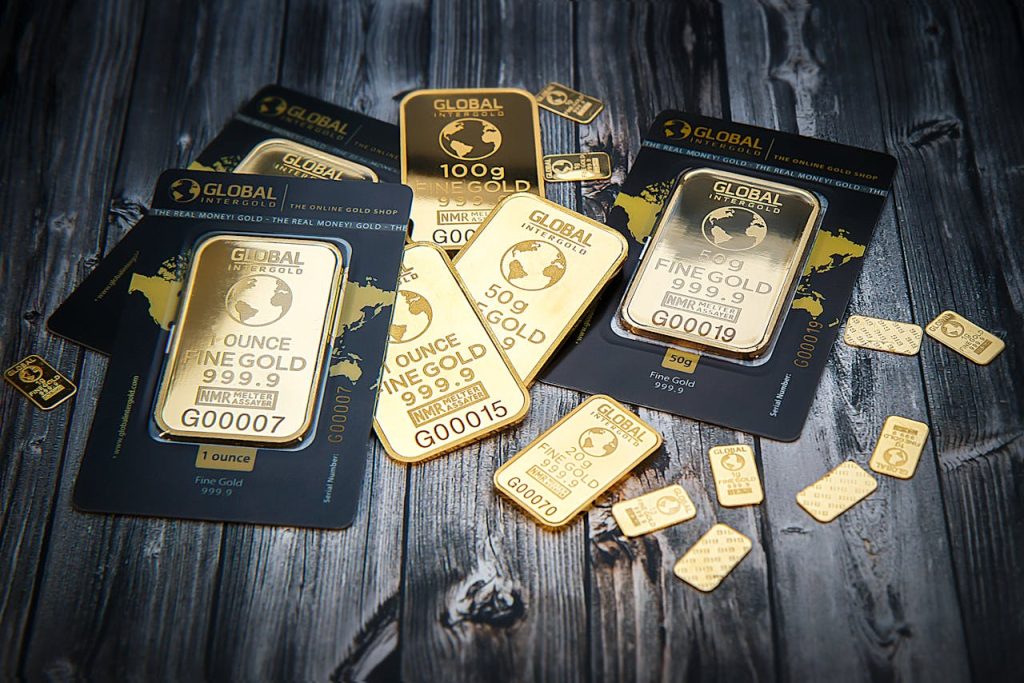 pexels-photo-318820 A collection of fine gold bars displayed on a textured wooden surface.
